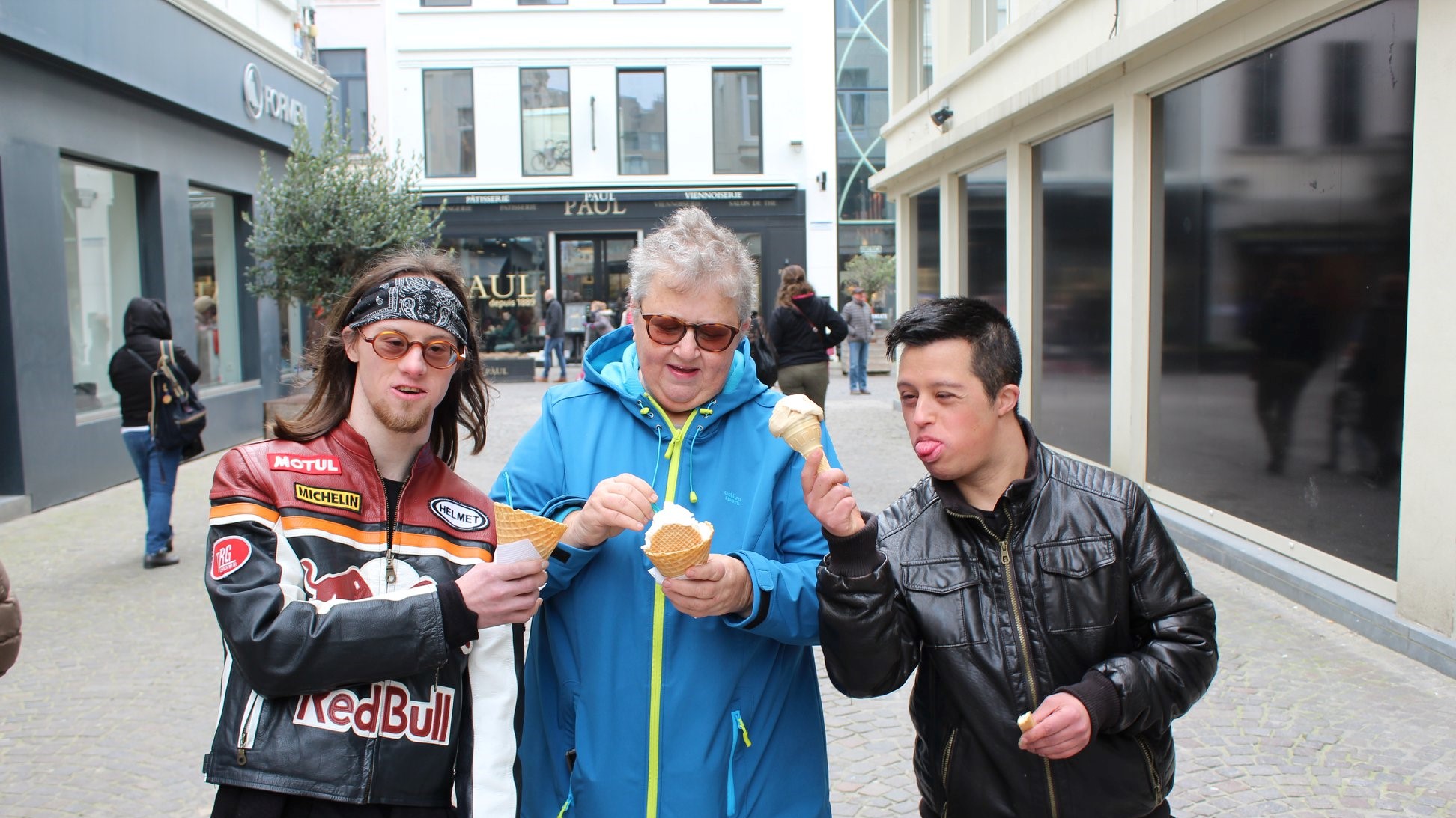 foto van mama met twee volwassen zonen die samen een ijsje eten