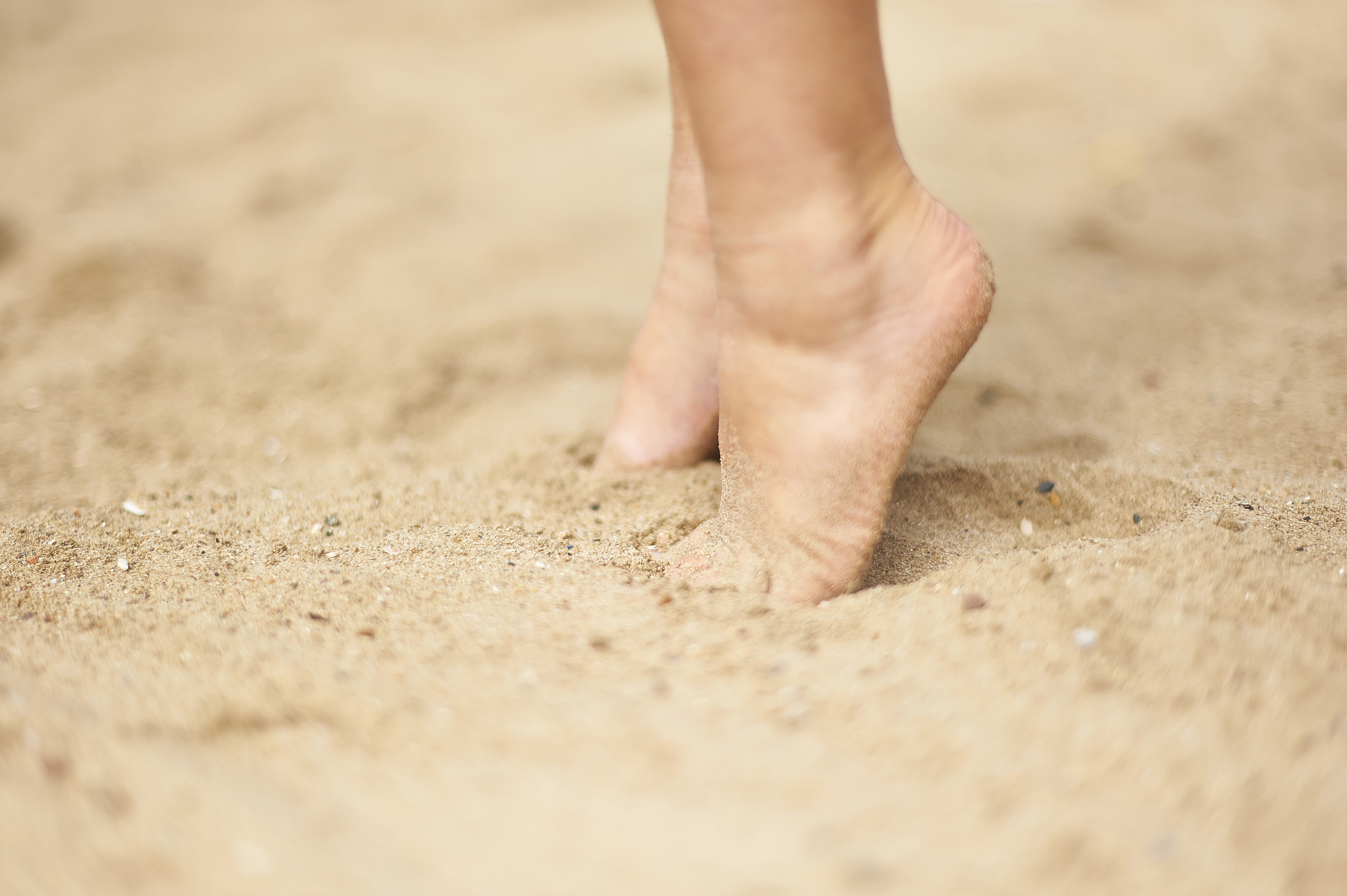 twee kindervoeten op de toppen van de tenen in het zand