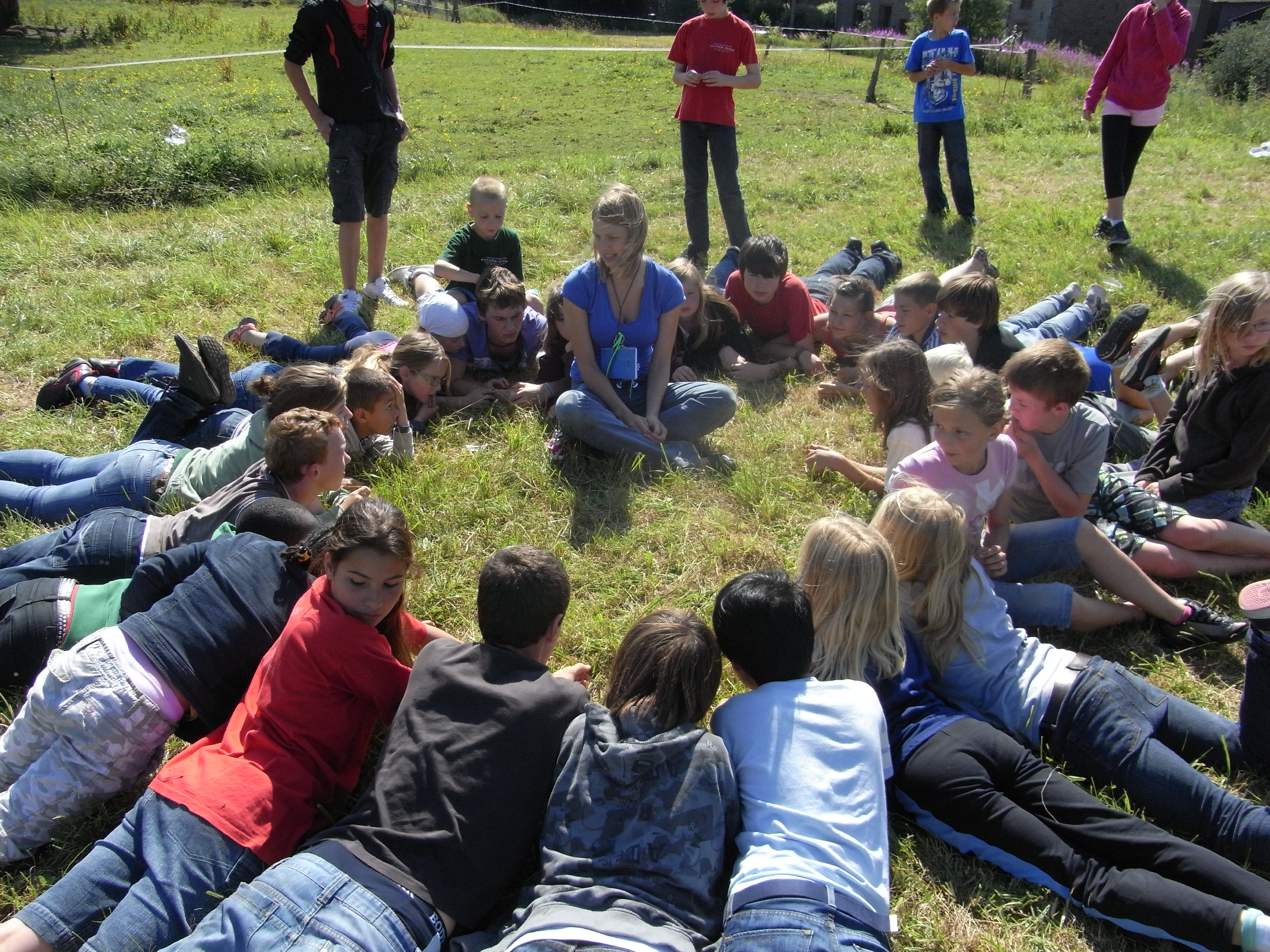 kinderen die op hun buik liggen rond persoon die verhaal vertelt